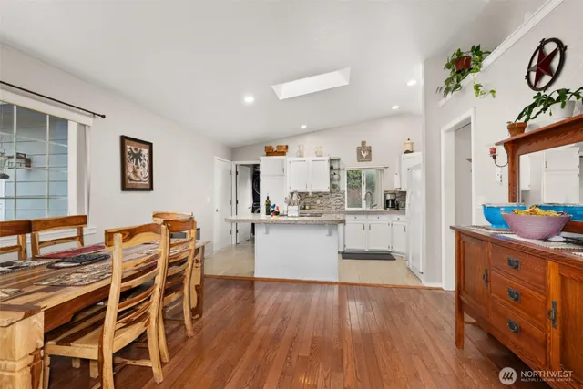 a kitchen with stainless steel appliances wooden floor and a refrigerator