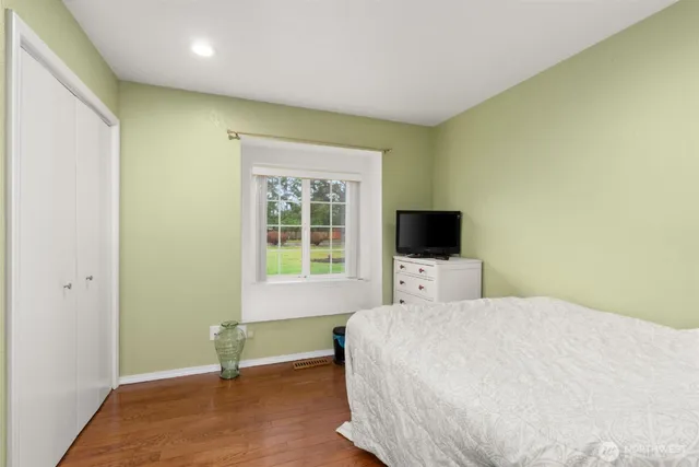 a bedroom with a bed and a flat screen tv