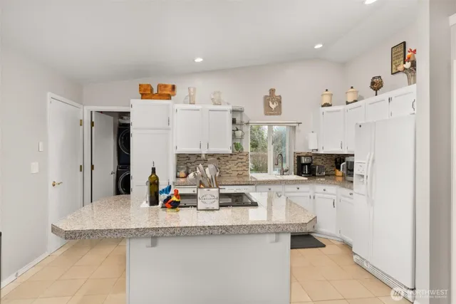 a kitchen with stainless steel appliances granite countertop a sink and a refrigerator