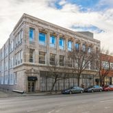 a city street lined with parked cars front of buildings