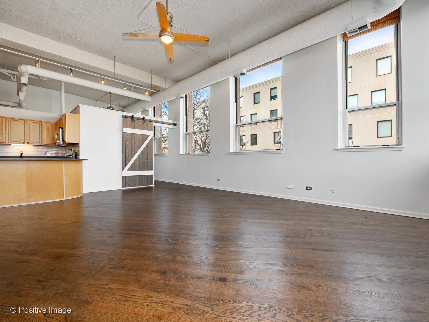 1019 West Jackson Boulevard, Unit 2B Chicago, IL 60607 - Photo 5 of 18 a view of a livingroom with wooden floor and a ceiling fan