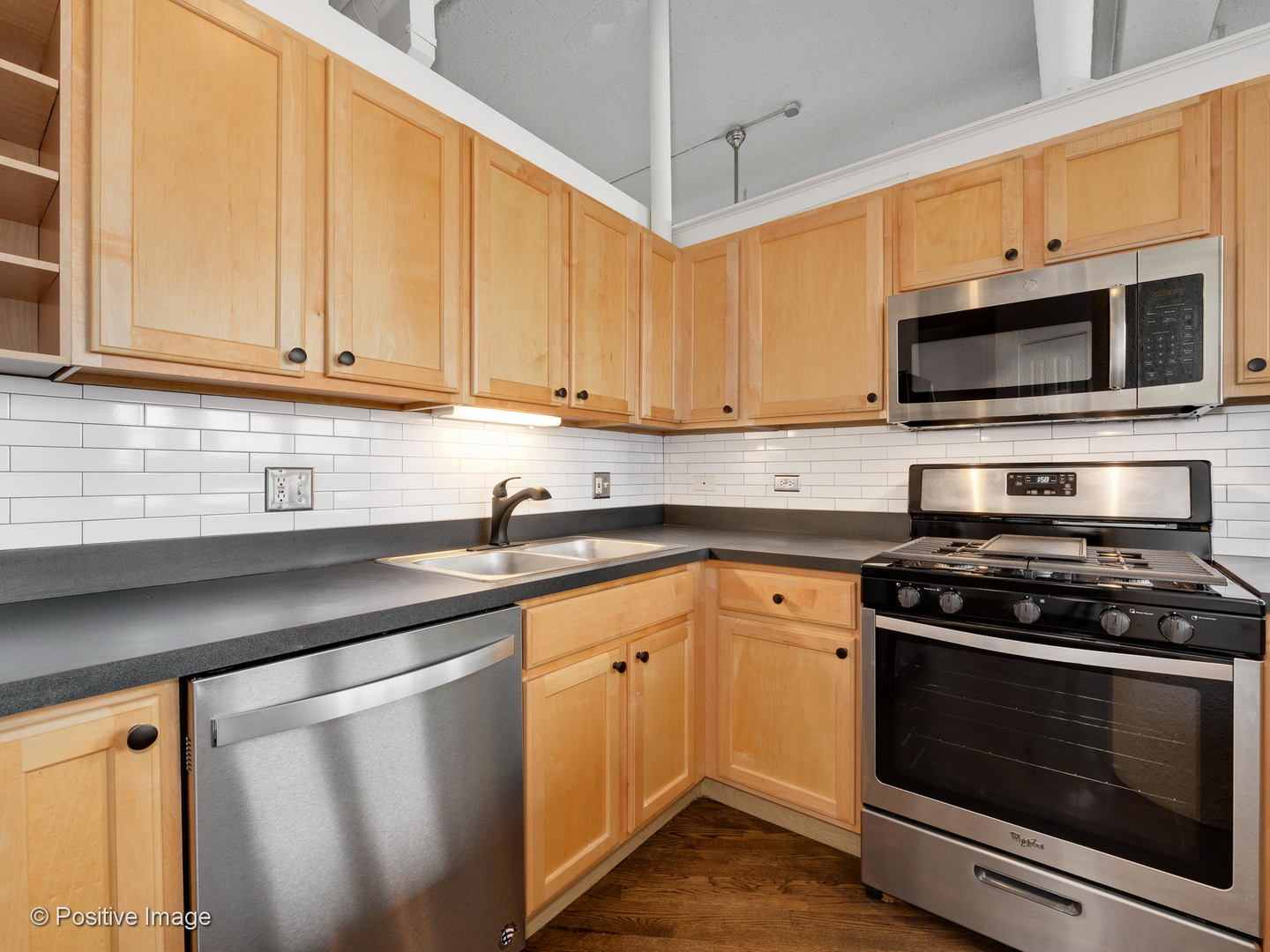 1019 West Jackson Boulevard, Unit 2B Chicago, IL 60607 - Photo 10 of 18 a kitchen with stainless steel appliances a stove a microwave sink and cabinets