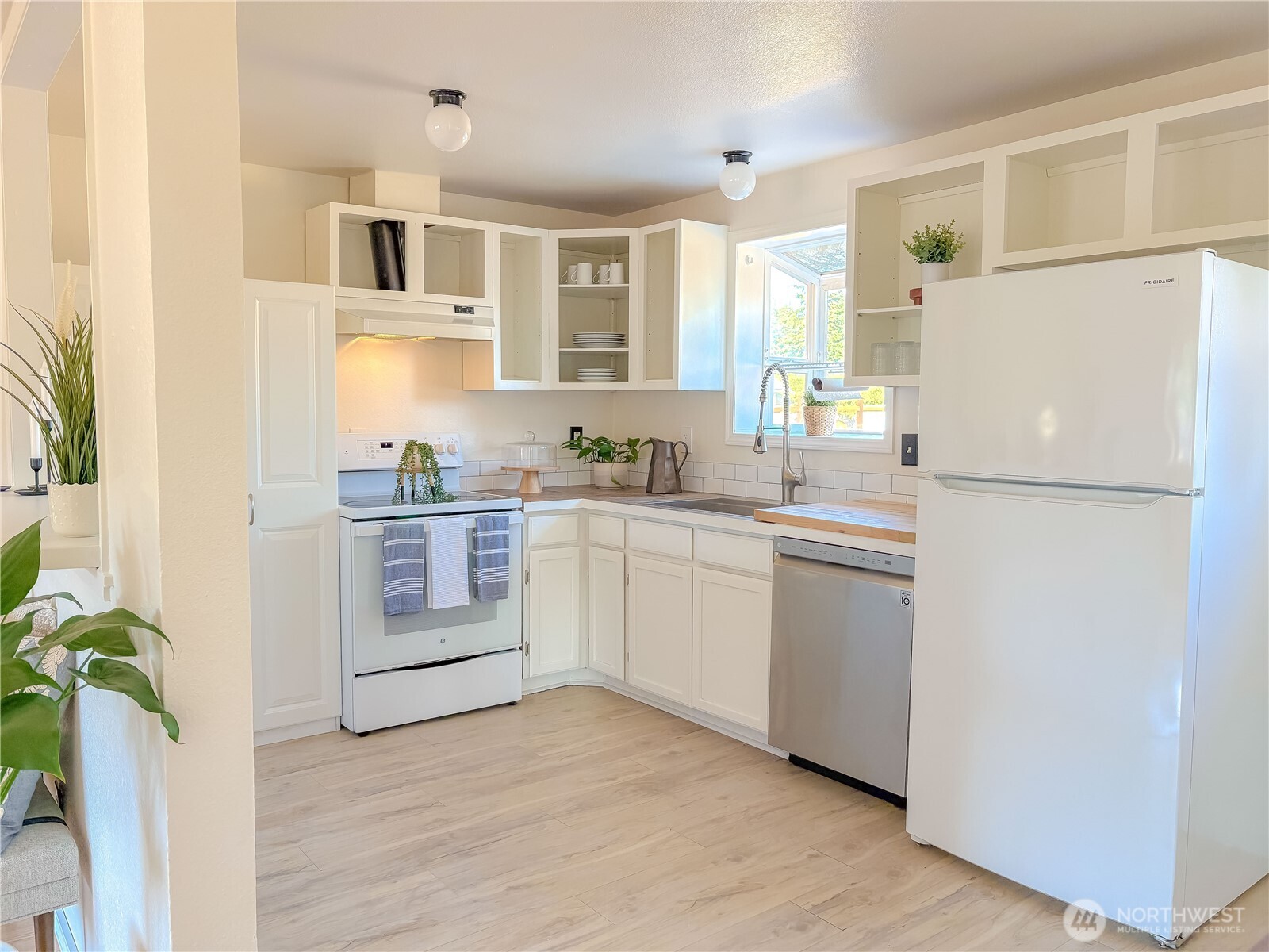 301 Seattle Street East Rainier, WA 98576 - Photo 7 of 18 a kitchen with white cabinets and white appliances