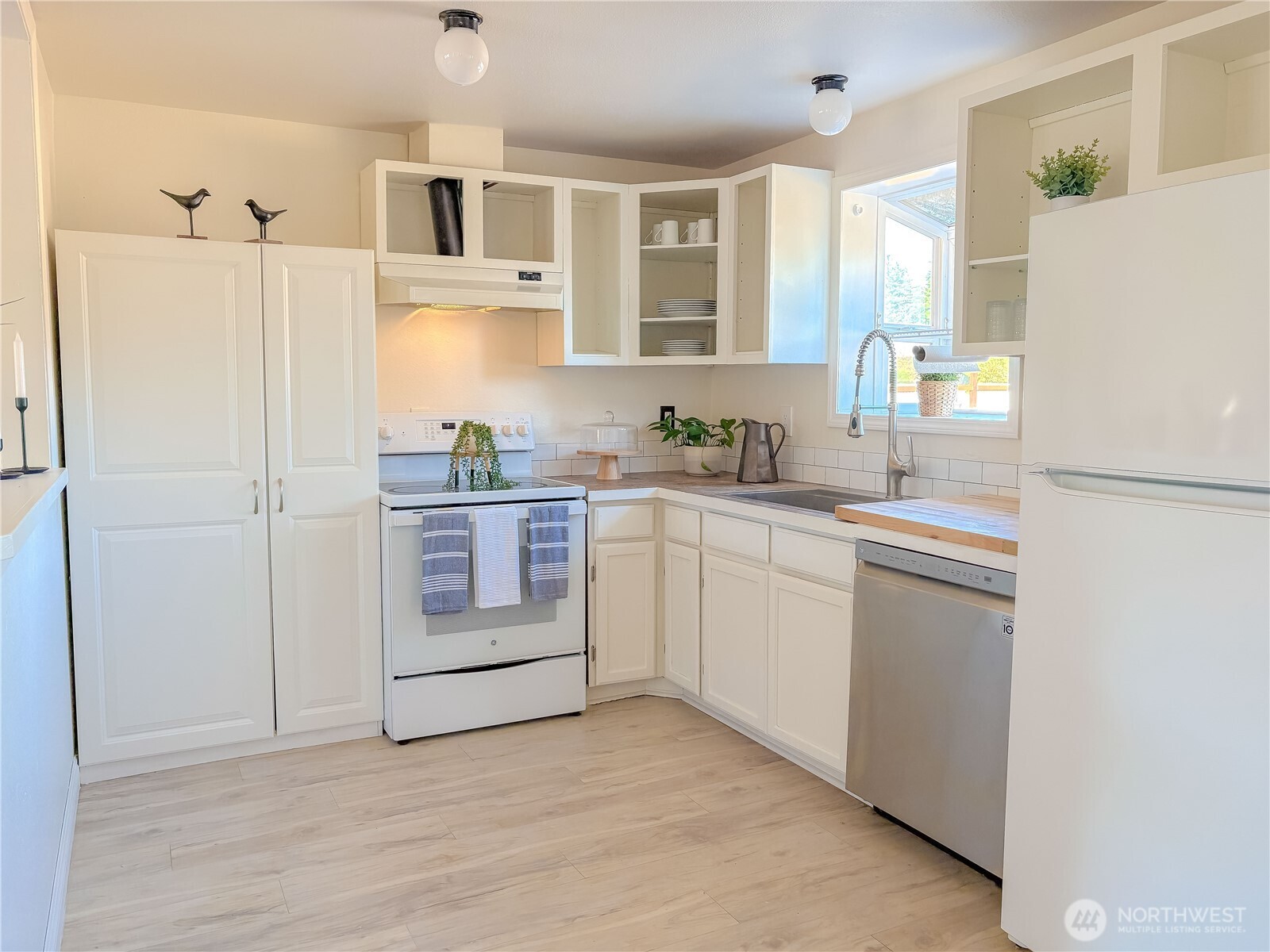 301 Seattle Street East Rainier, WA 98576 - Photo 8 of 18 a kitchen with white cabinets and white appliances