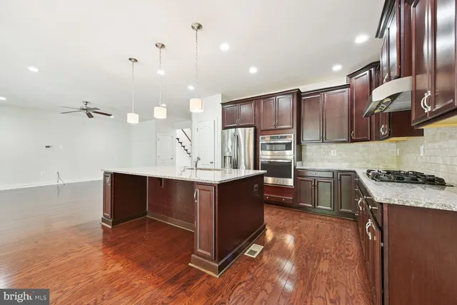 a kitchen with a stove and a wooden floor