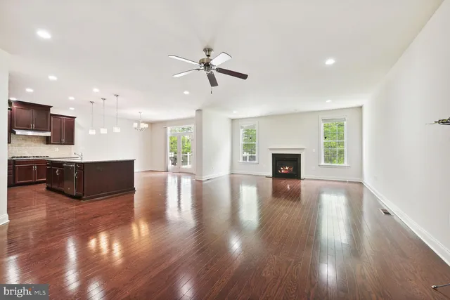 a view of a big room with wooden floor and a kitchen