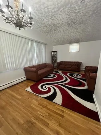 a view of a room with furniture and wooden floor