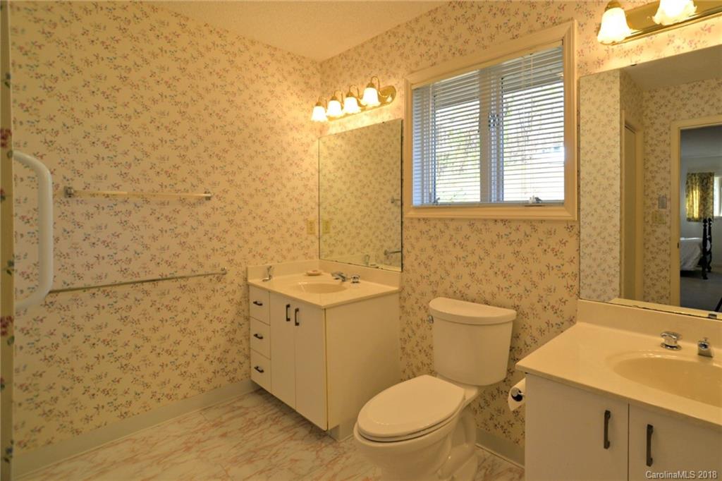 724 Laurel Ridge Road, Unit 23&24 Columbus, NC 28722 - Photo 17 of 25 a bathroom with a granite countertop toilet sink and mirror