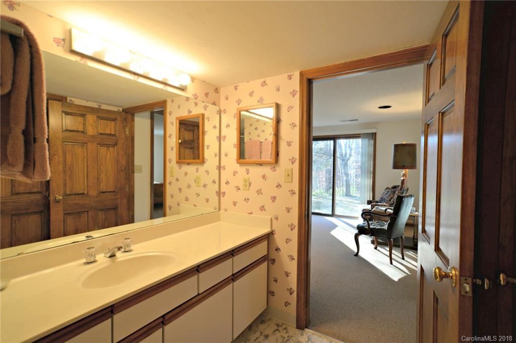724 Laurel Ridge Road, Unit 23&24 Columbus, NC 28722 - Photo 21 of 25 a en suite bathroom with a double vanity sink a large mirror and a shower