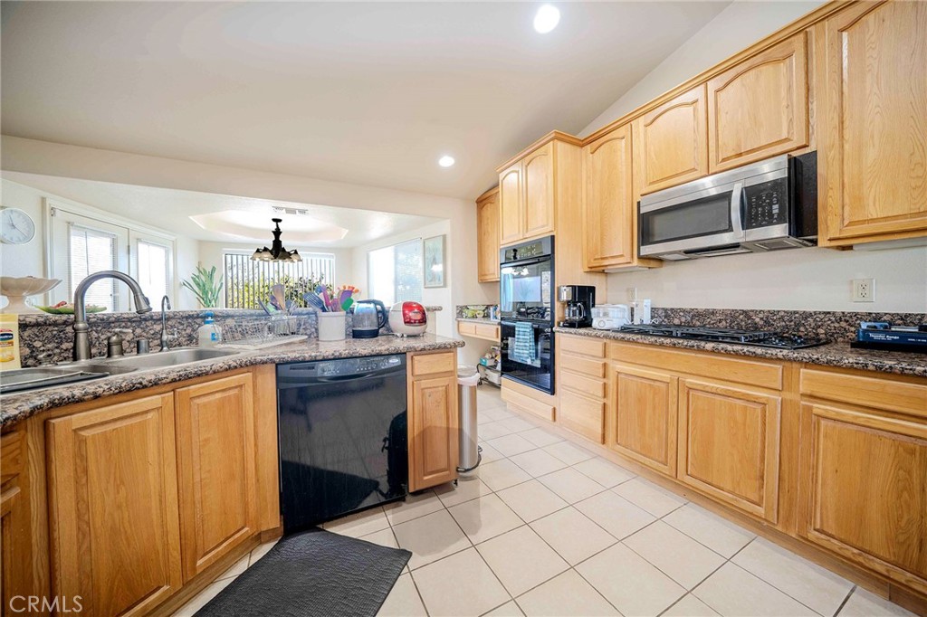 11522 Ponderosa Road Pinon Hills, CA 92372 - Photo 22 of 46 a kitchen with stainless steel appliances granite countertop a stove top oven a sink dishwasher and cabinets with wooden floor