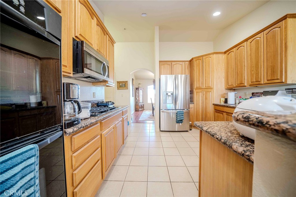 11522 Ponderosa Road Pinon Hills, CA 92372 - Photo 23 of 46 a kitchen with stainless steel appliances granite countertop a stove a sink and a microwave