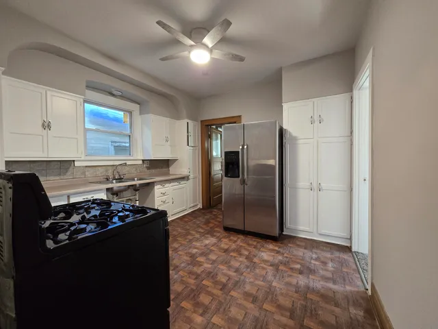 a kitchen with stainless steel appliances granite countertop a refrigerator a stove a sink and a refrigerator