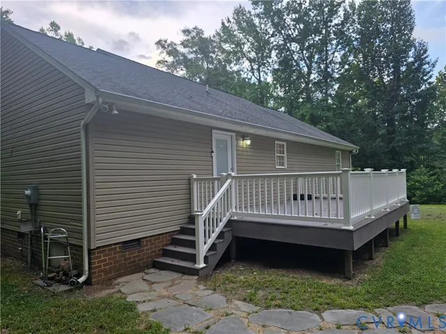 a view of a white house with a yard and a deck