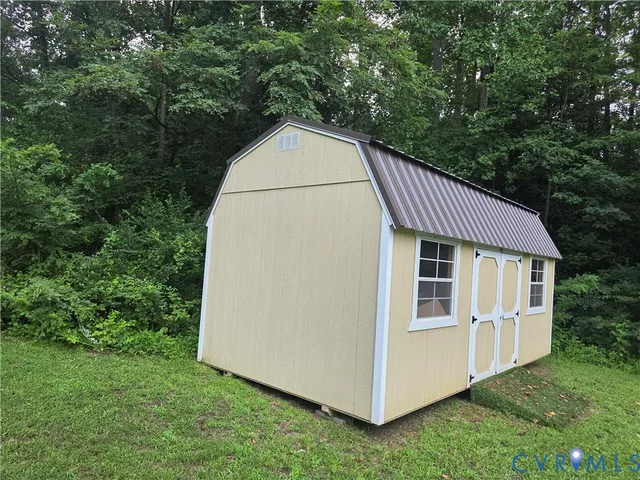 a backyard of a house with large trees and plants