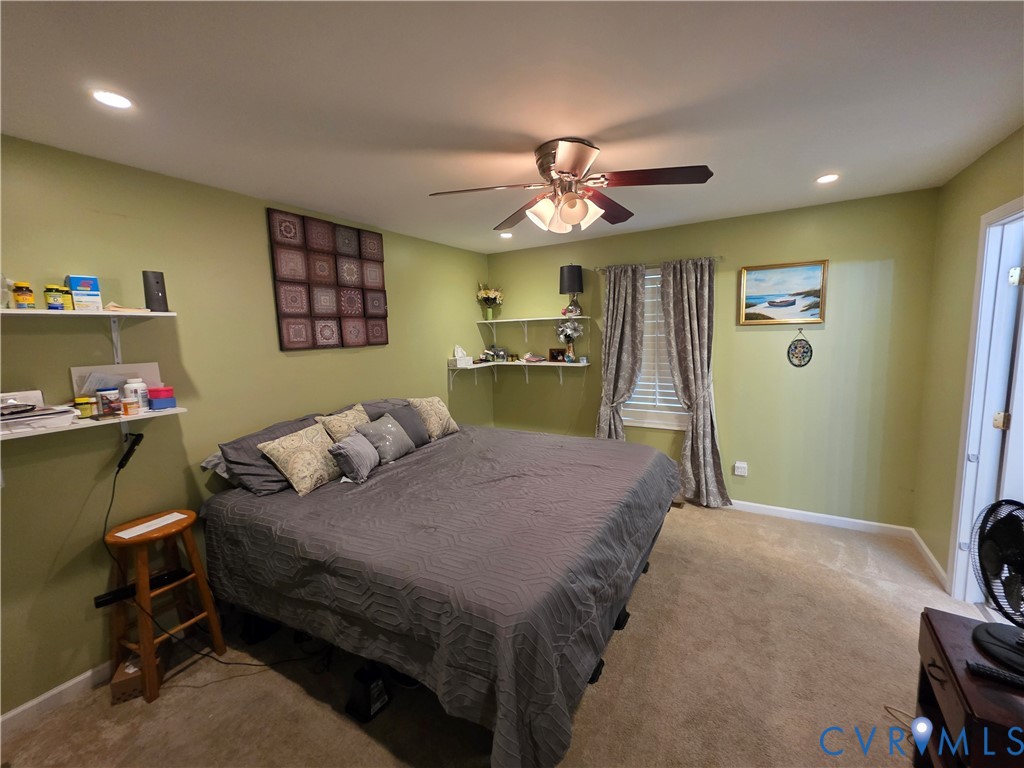416 Berry Hill Road Tappahannock, VA 22560 - Photo 6 of 18 a bedroom with a bed and a chandelier
