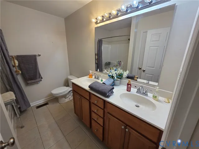 a bathroom with a sink vanity granite and toilet