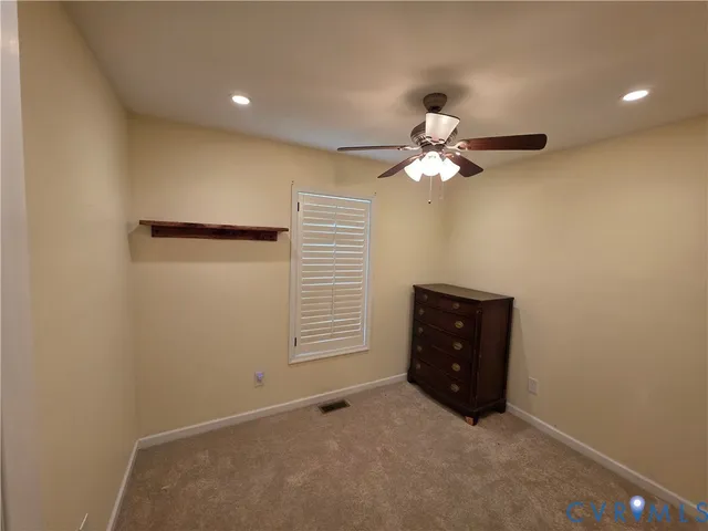an empty room with closet and a chandelier fan