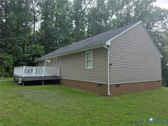 a view of a house with a backyard and wooden deck