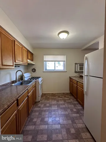 a kitchen with granite countertop a refrigerator stove top oven and sink