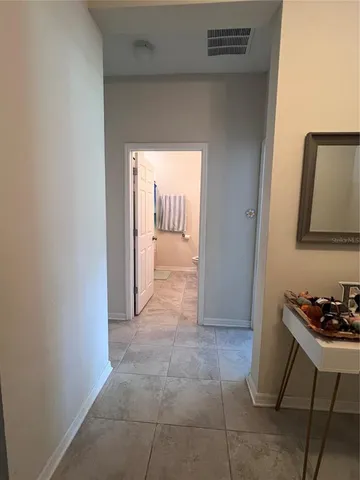 a view of a hallway to room with furniture