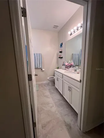 a bathroom with a sink vanity toilet and a mirror