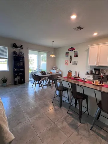 a room with furniture a dining table and a refrigerator