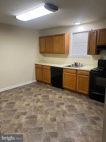 a large kitchen with granite countertop a sink and a stove