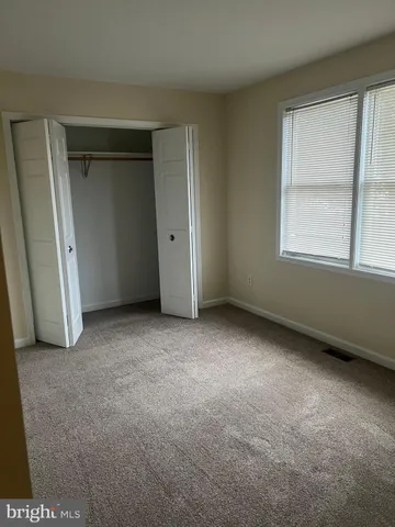 an empty room with windows and closet