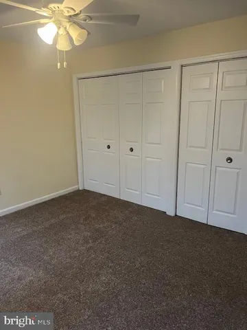 a view of an empty room and chandelier fan