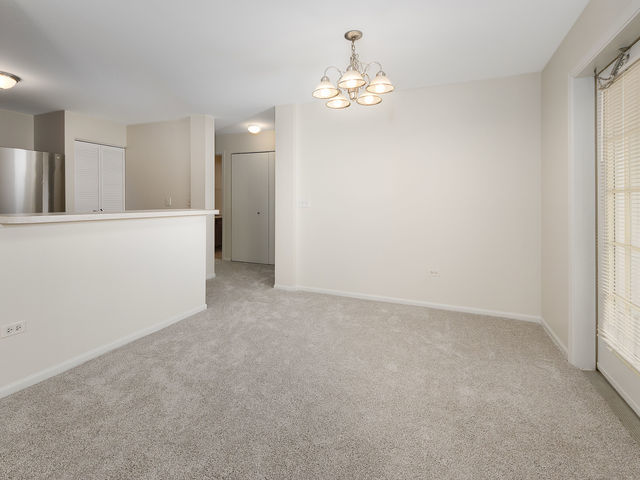 1309 Silverstone Drive, Unit 1309 Carpentersville, IL 60110 - Photo 4 of 12 a view of a hallway with chandelier