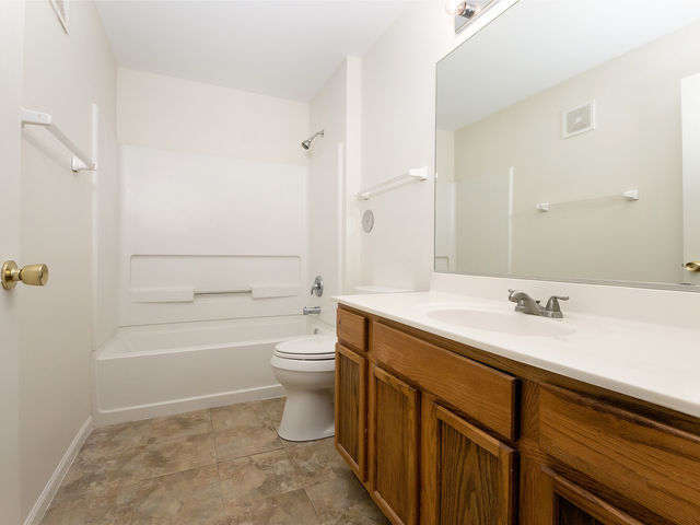 1309 Silverstone Drive, Unit 1309 Carpentersville, IL 60110 - Photo 9 of 12 a bathroom with a sink a toilet and shower