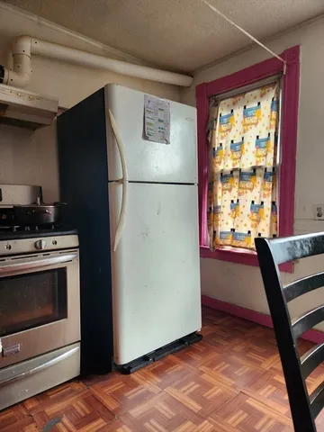 a view of kitchen with furniture refrigerator and window