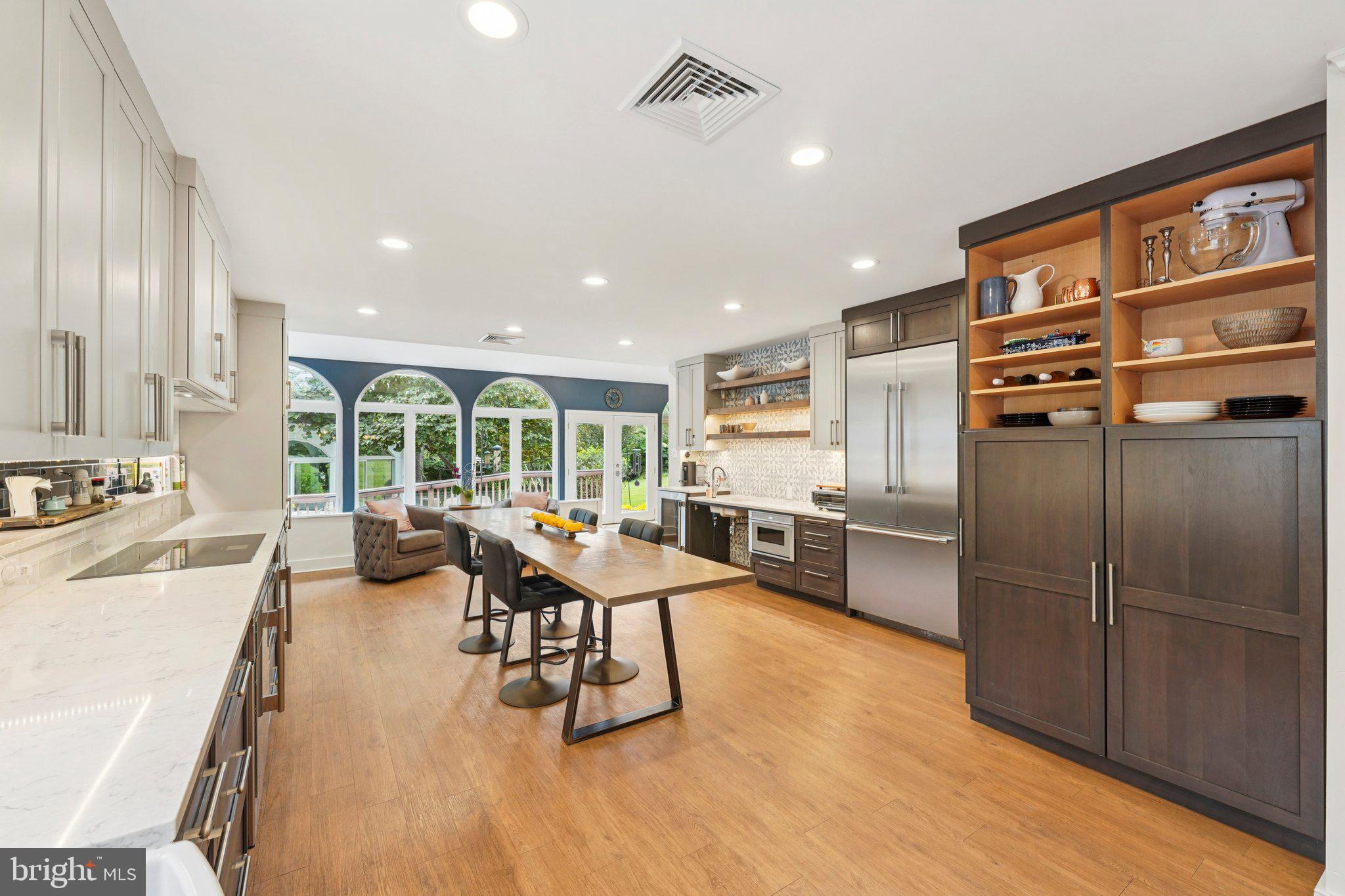 1535 Scrope Road Rydal, PA 19046 - Photo 21 of 63 a kitchen with stainless steel appliances kitchen island granite countertop a refrigerator a stove a dining table and chairs with wooden floor