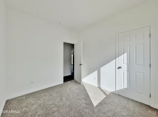 an empty room with a hallway and white walls