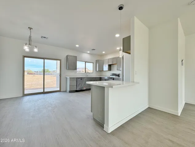 a view of a kitchen with wooden floor and a window