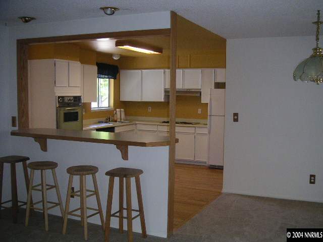 1485 Exeter Way Reno, NV 89503 - Photo 2 of 3 a kitchen with stainless steel appliances a sink cabinets dining table and chairs