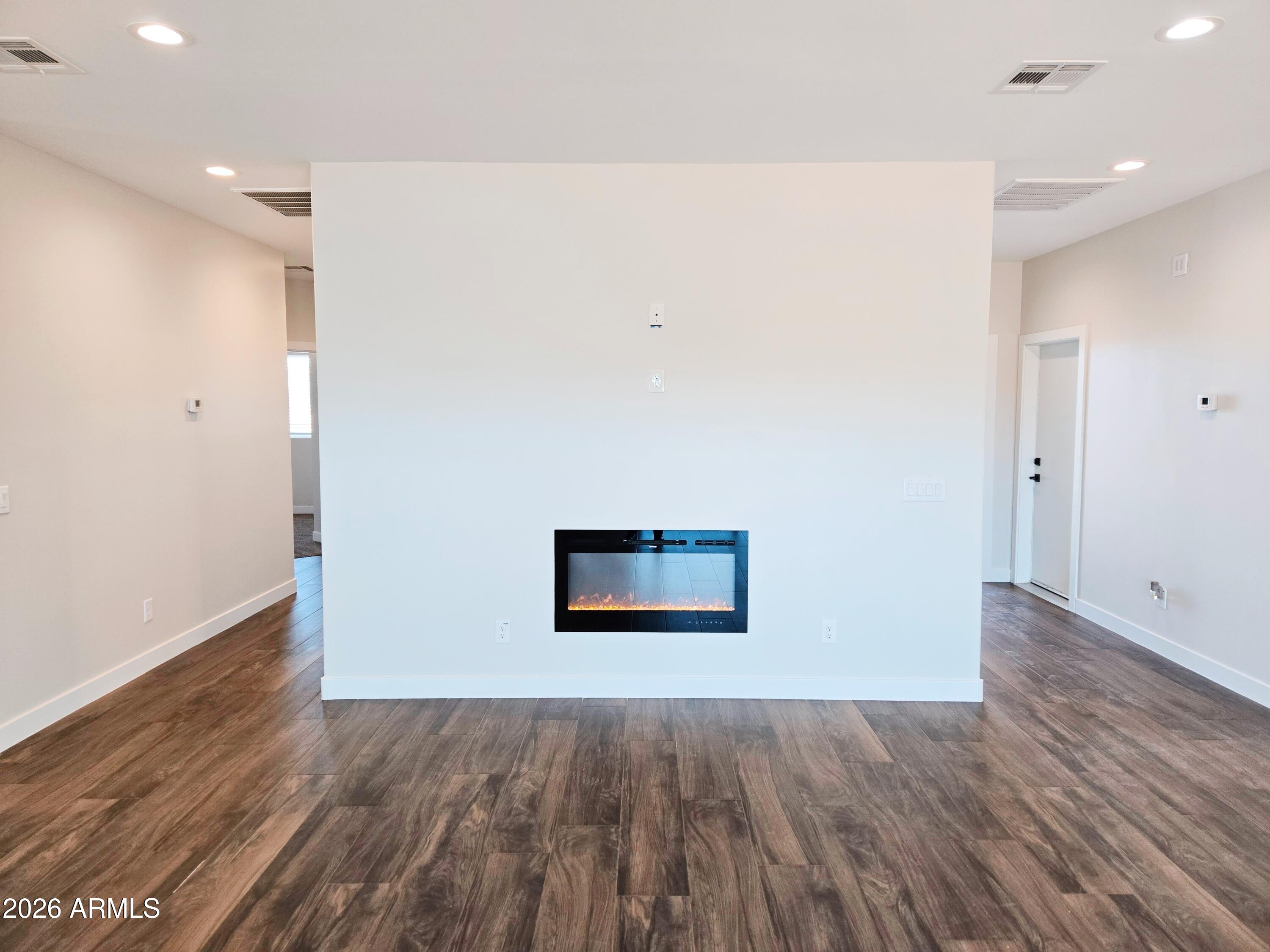 20735 West Elliot Road Buckeye, AZ 85326 - Photo 12 of 59 an empty room with wooden floor and windows