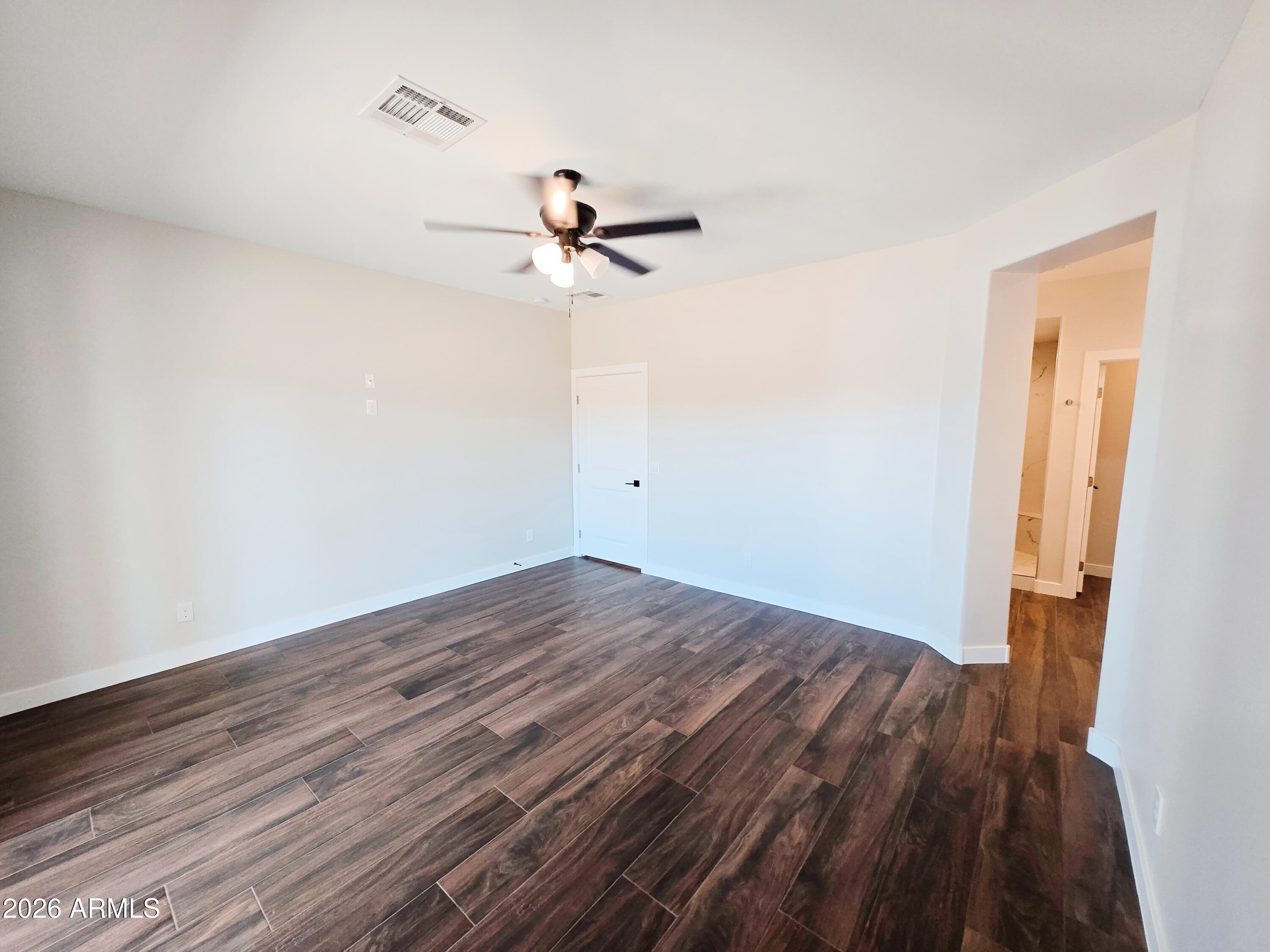 20735 West Elliot Road Buckeye, AZ 85326 - Photo 26 of 59 a view of a room with wooden floor and ceiling fan