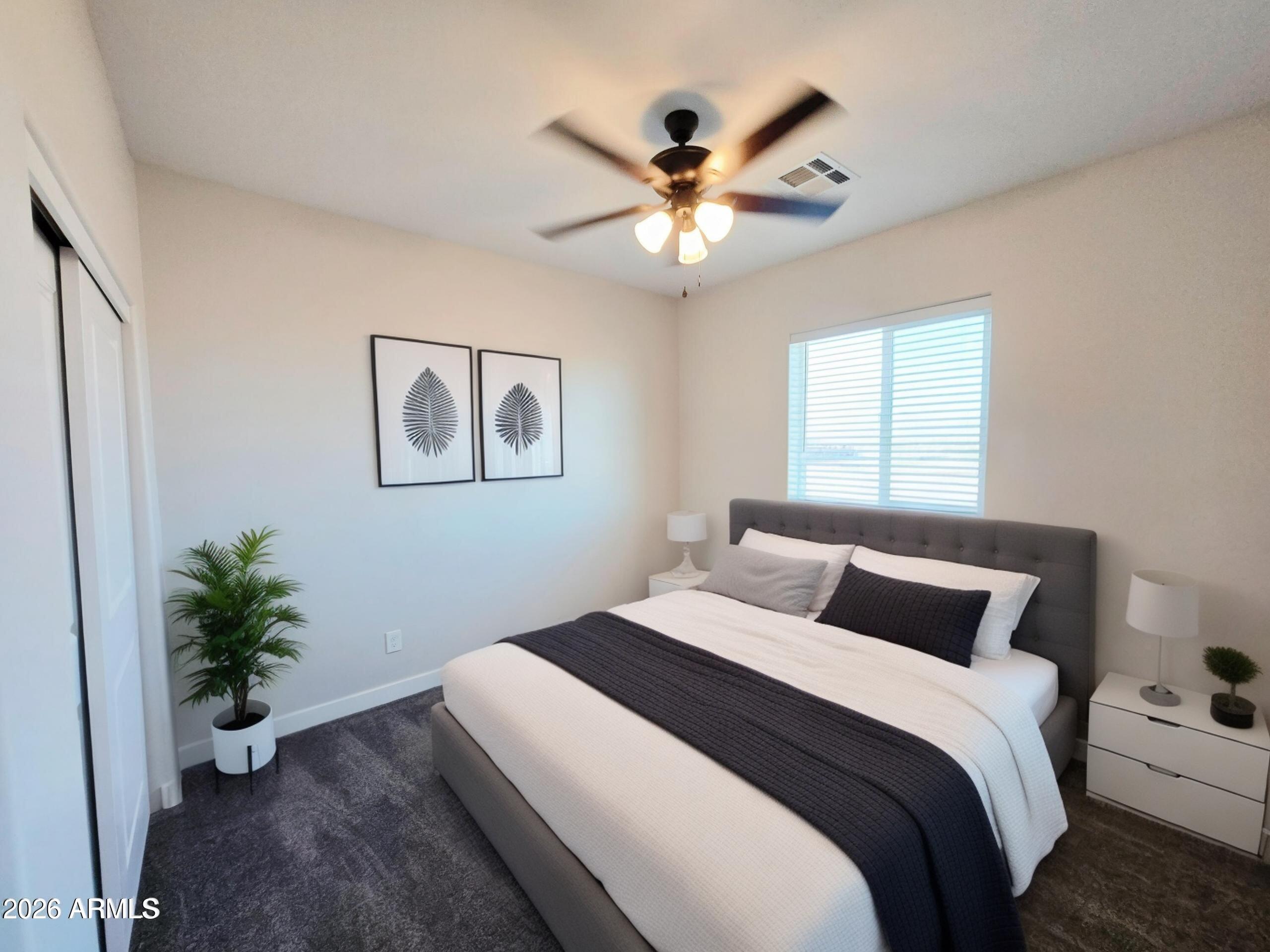 20735 West Elliot Road Buckeye, AZ 85326 - Photo 38 of 59 a bedroom with a large bed and a potted plant