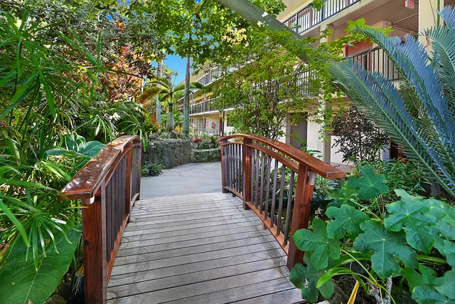 a balcony with wooden floor and trees in the back