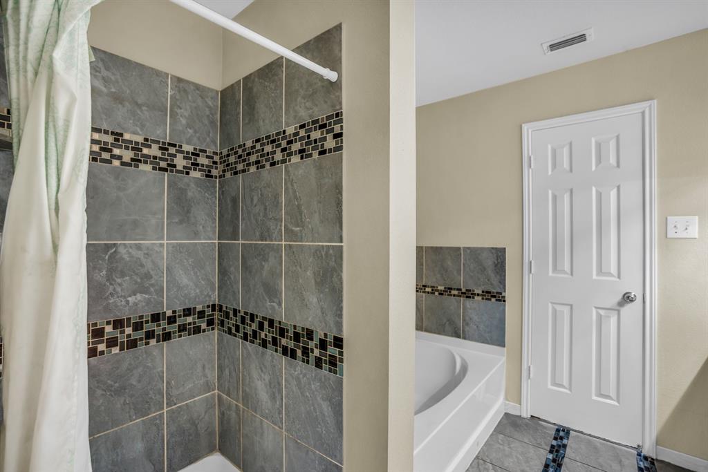 5718 Green Ivy Road Denton, TX 76210 - Photo 20 of 37 Shower with gray large-format tile and a decorative mosaic accent band