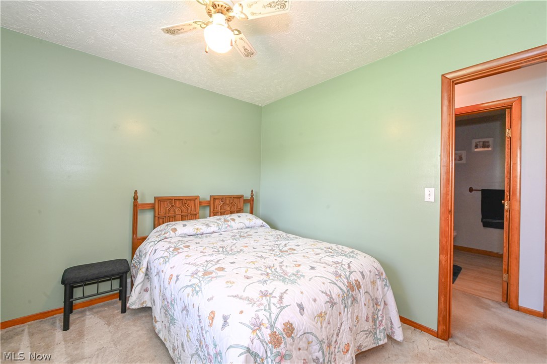 13425 Chardon-Windsor Road Chardon, OH 44024 - Photo 22 of 50 Bedroom featuring a textured ceiling, ceiling fan, and carpet