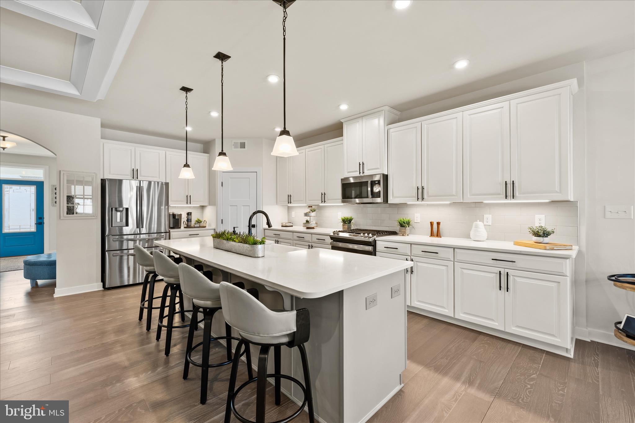 32225 Heritage Road Lewes, DE 19958 - Photo 12 of 74 a kitchen with stainless steel appliances kitchen island a table chairs sink and cabinets