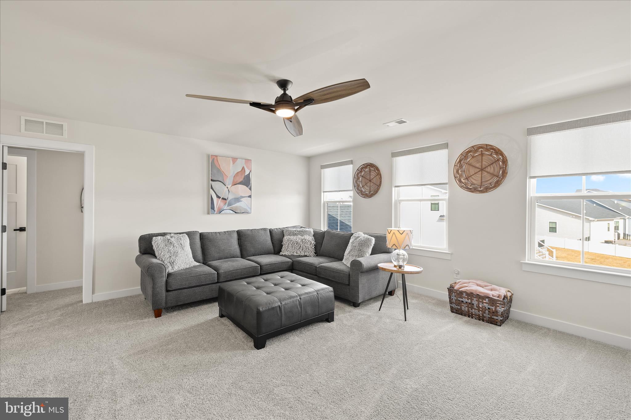32225 Heritage Road Lewes, DE 19958 - Photo 37 of 74 a living room with couches a large window and a clock