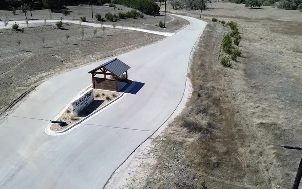 an aerial view of residential houses with outdoor space and trees