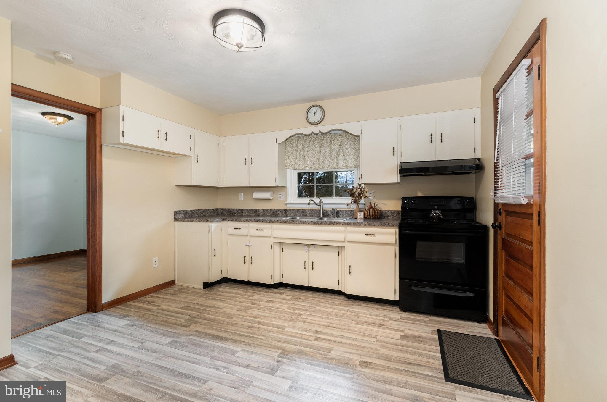 20 Chestnut Street Camp Hill, PA 17011 - Photo 10 of 26 a kitchen with granite countertop a refrigerator oven a sink dishwasher and white cabinets with wooden floor