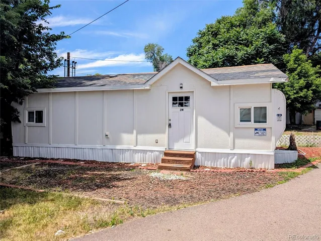 a view of a white house with a yard and large tree
