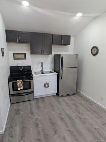 a kitchen with a refrigerator and a stove top oven