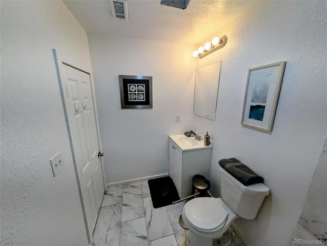 a white toilet sitting next to a bathroom sink and a mirror