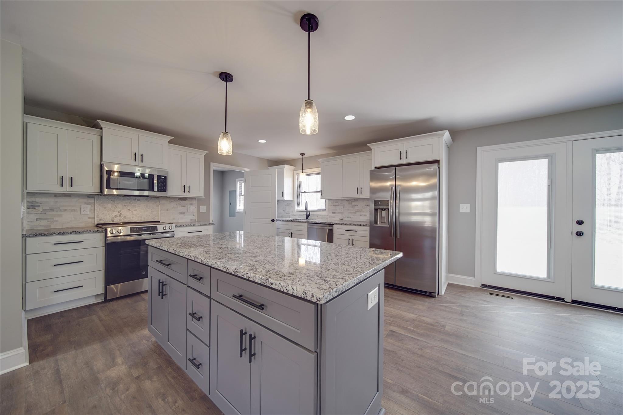 3210 Puetts Chapel Road Dallas, NC 28034 - Photo 2 of 11 a kitchen with kitchen island granite countertop a sink cabinets and stainless steel appliances